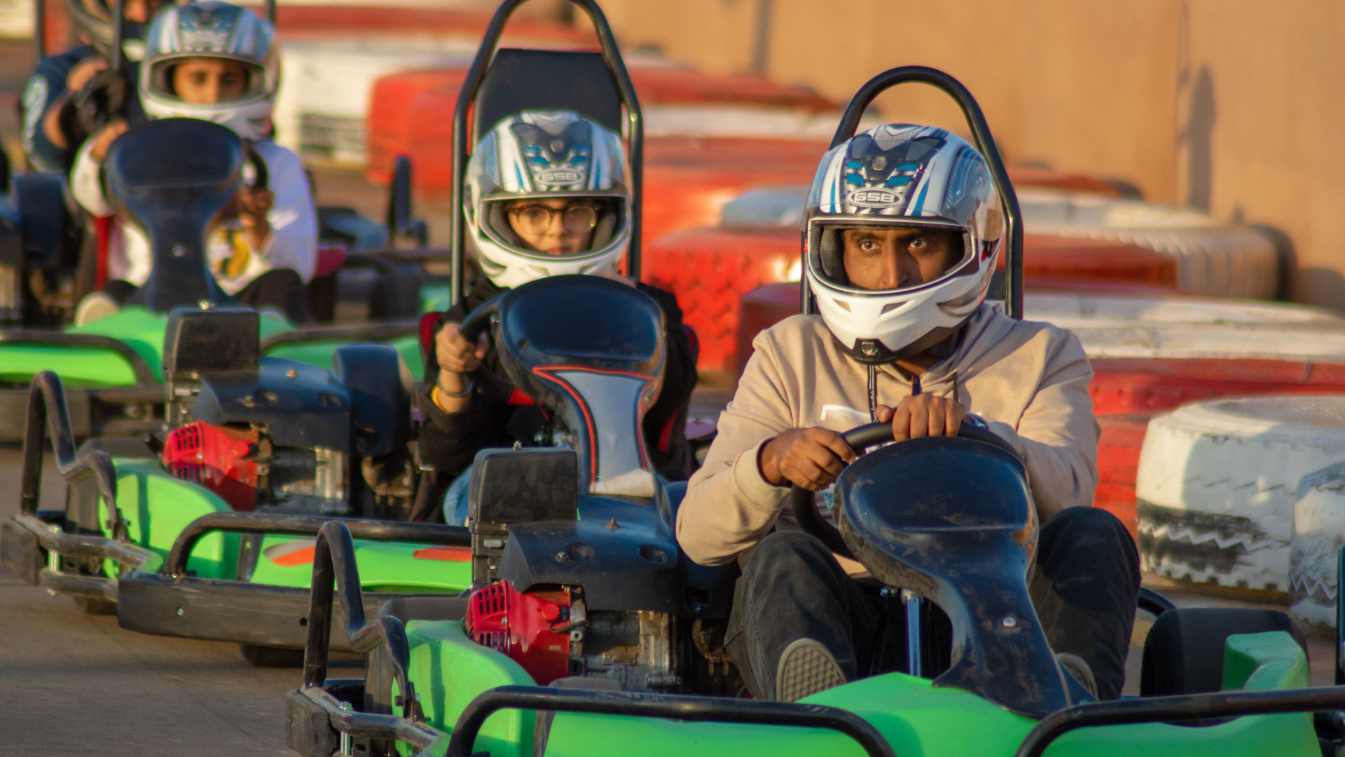 Racers in go-karts, focusing intently as they drive.