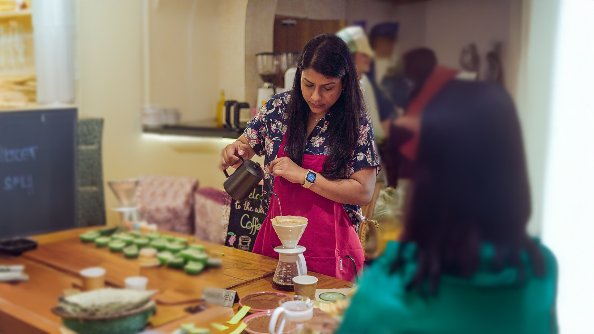 Woman focused on brewing coffee with pour-over method inside a cozy cafe environment.