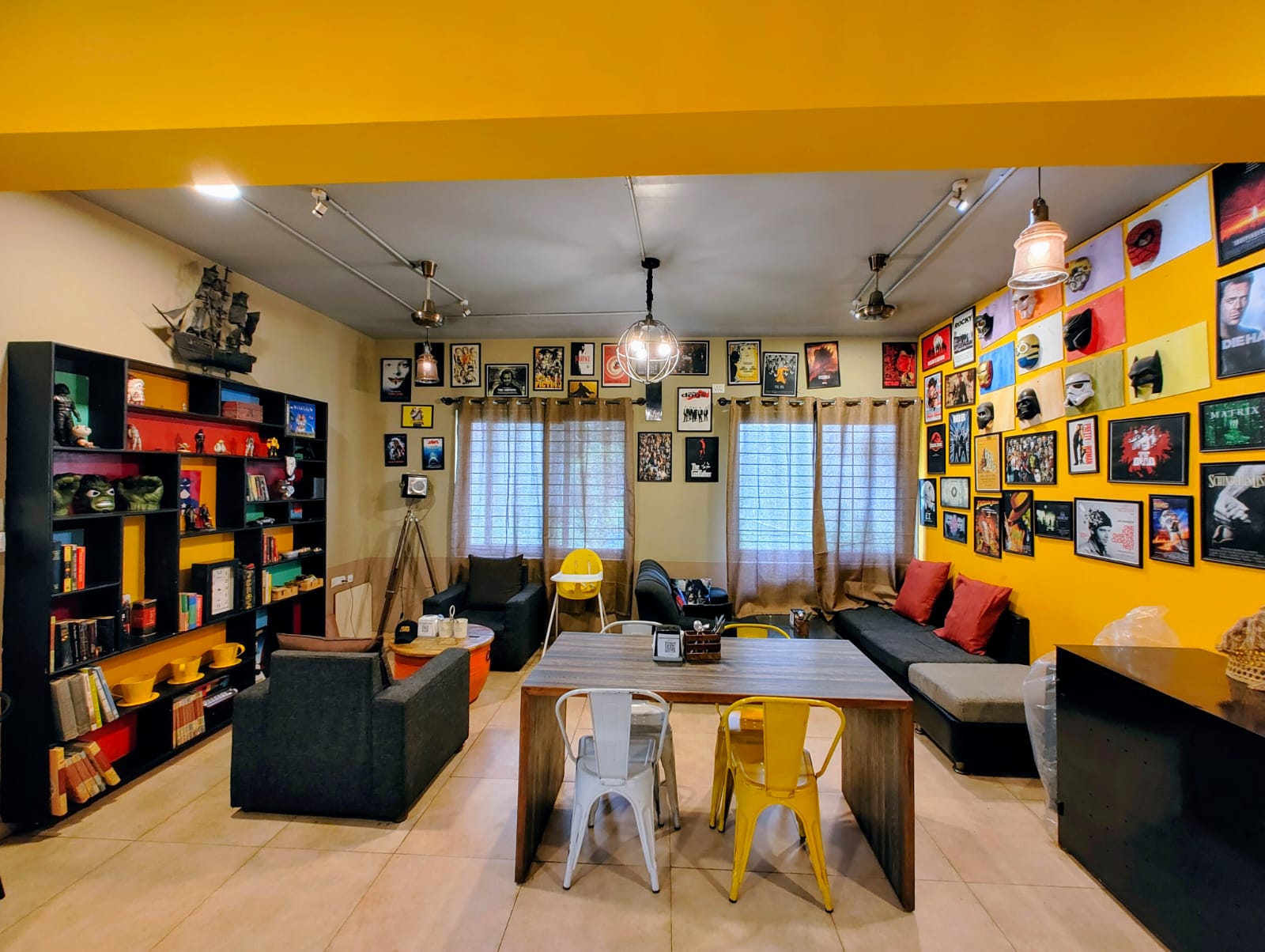 Interior view of a vibrant coffee space decorated with posters and comfortable seating.