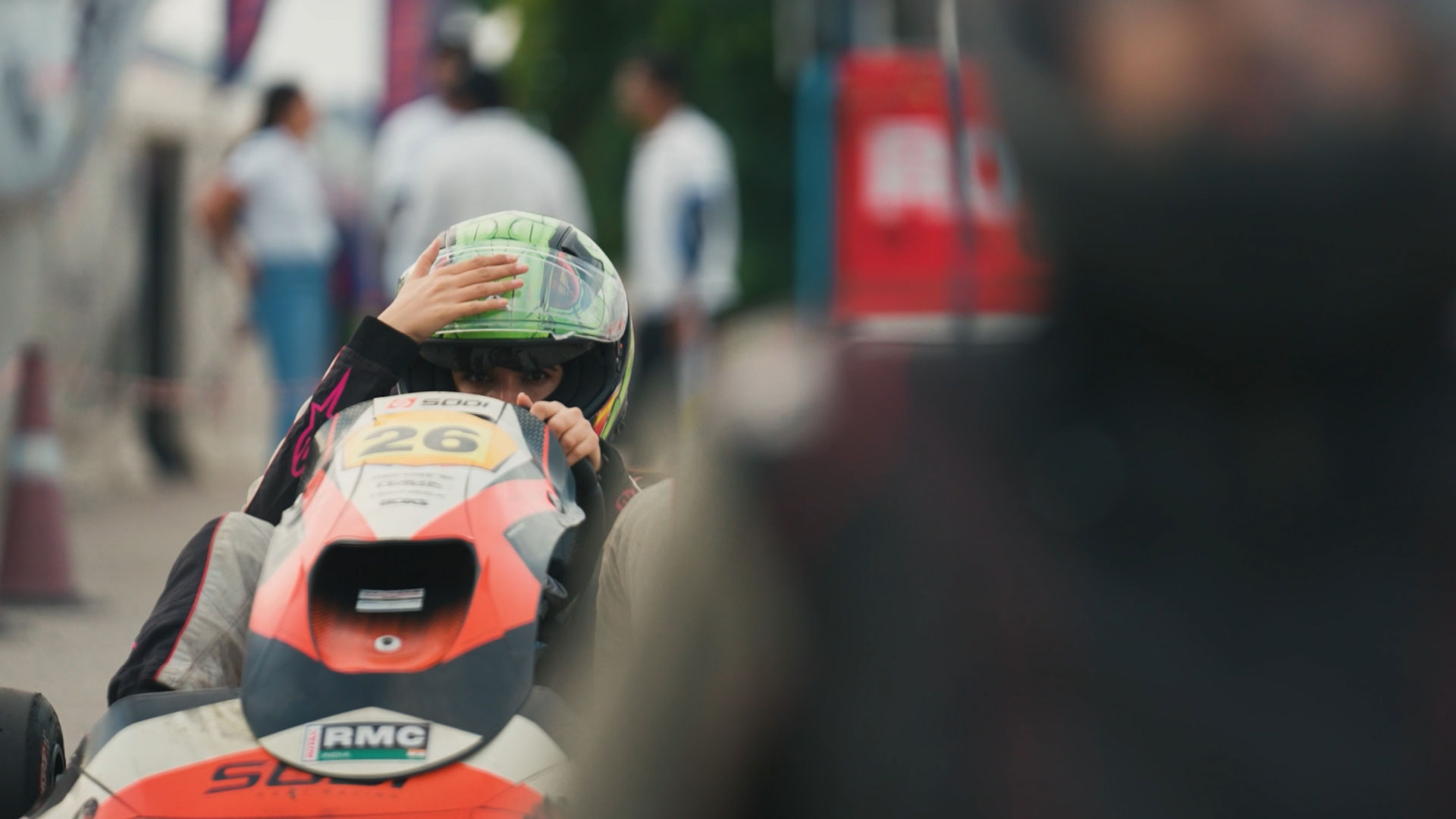 A woman preparing to race, adjusting her helmet.