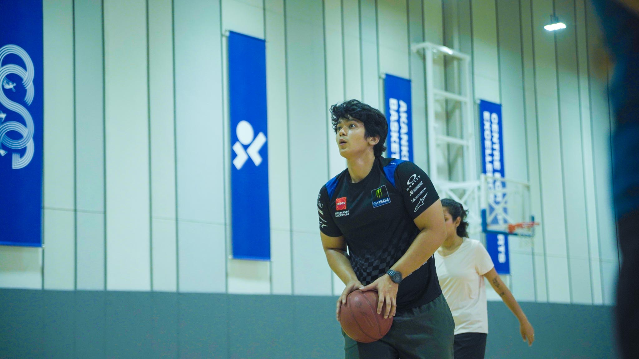 Young man holding basketball focusing for shot inside indoor basketball court as part of The Ultimate Weekend Playday.