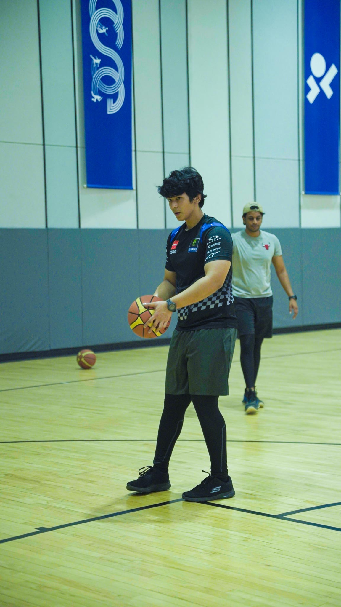 Young woman standing on court preparing to dribble basketball inside Bengaluru’s top basketball facility.