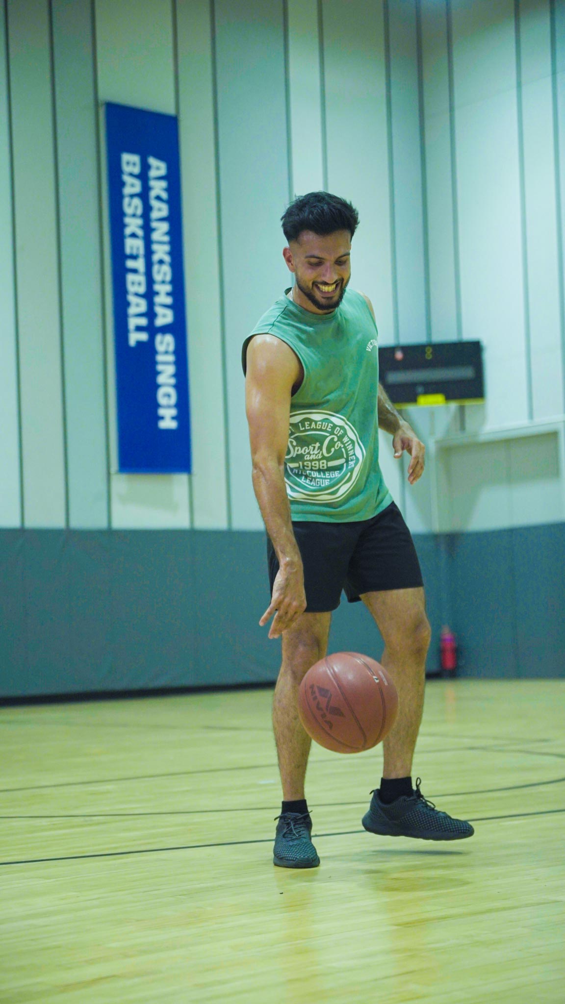 Group of basketball players holding balls and discussing strategy during Bengaluru session.