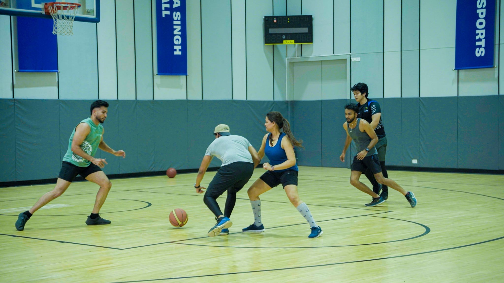 Group of basketball players actively engaged in a game on a Bengaluru indoor court.