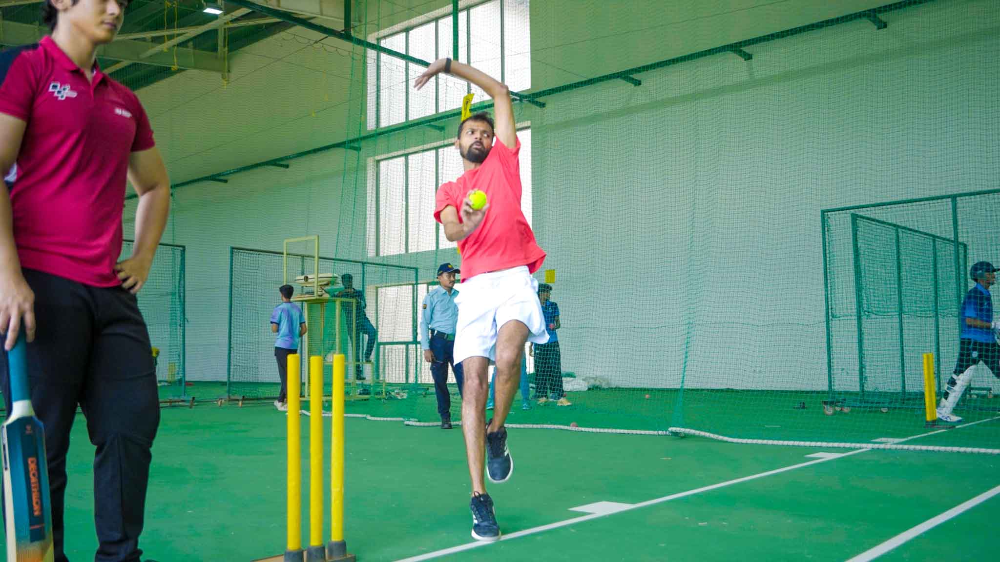 Man bowling a cricket ball indoor during cricket practice in Bengaluru