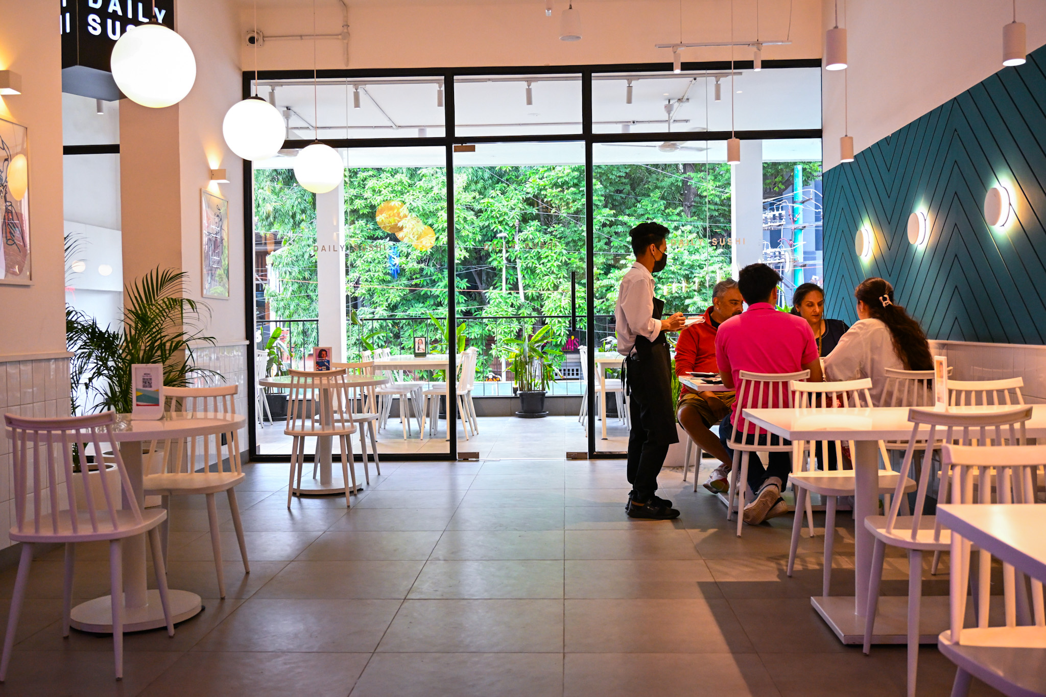 Freshly prepared sushi and bento meals laid out on a white dining table with plates and chopsticks.