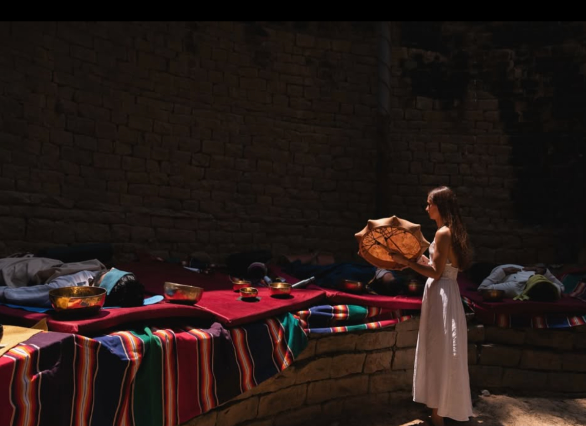 Participants sitting calmly in circle during cacao ceremony with live music bowls