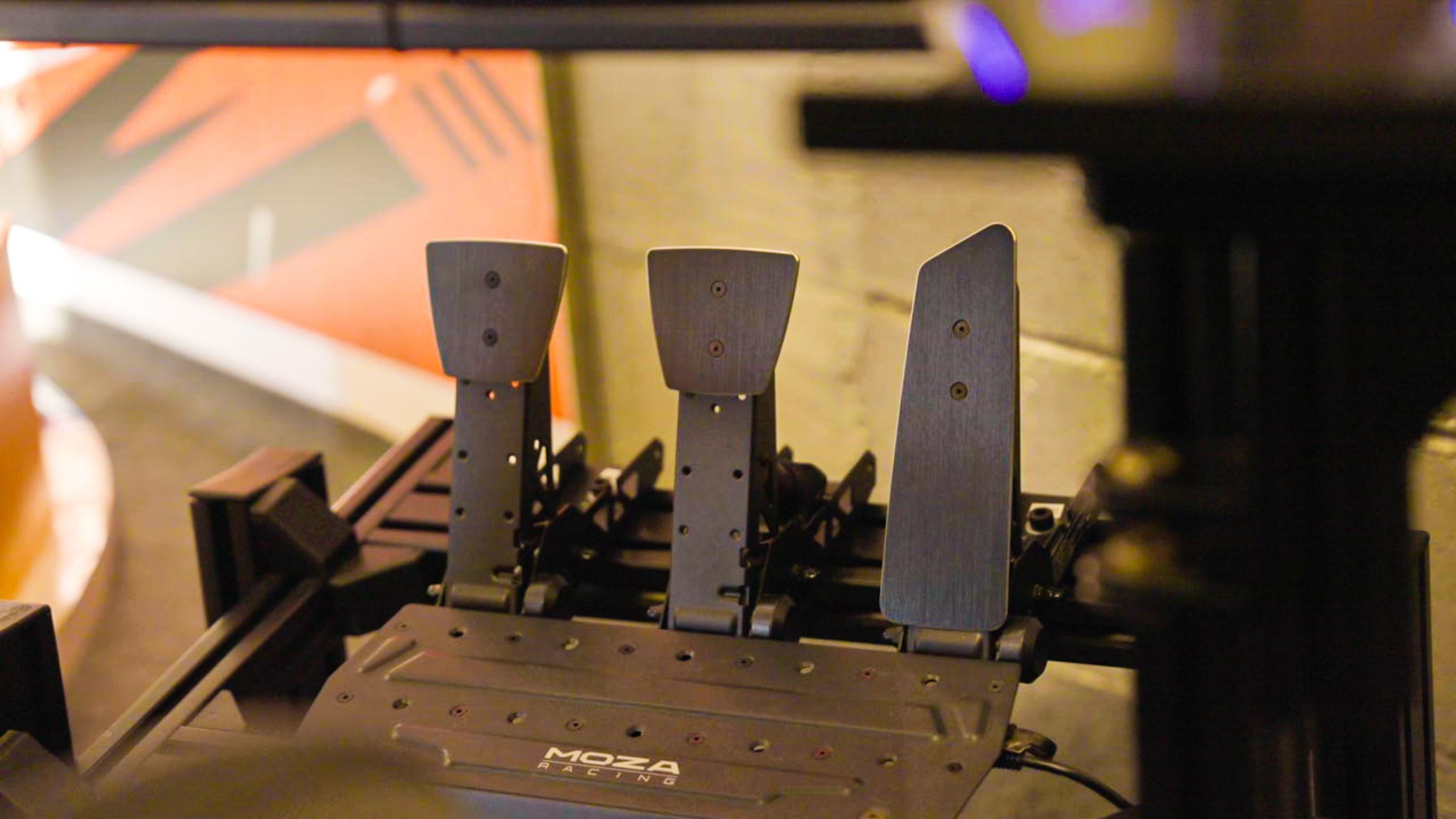 Close-up of three racing pedals in the Formula 1 simulator setup.