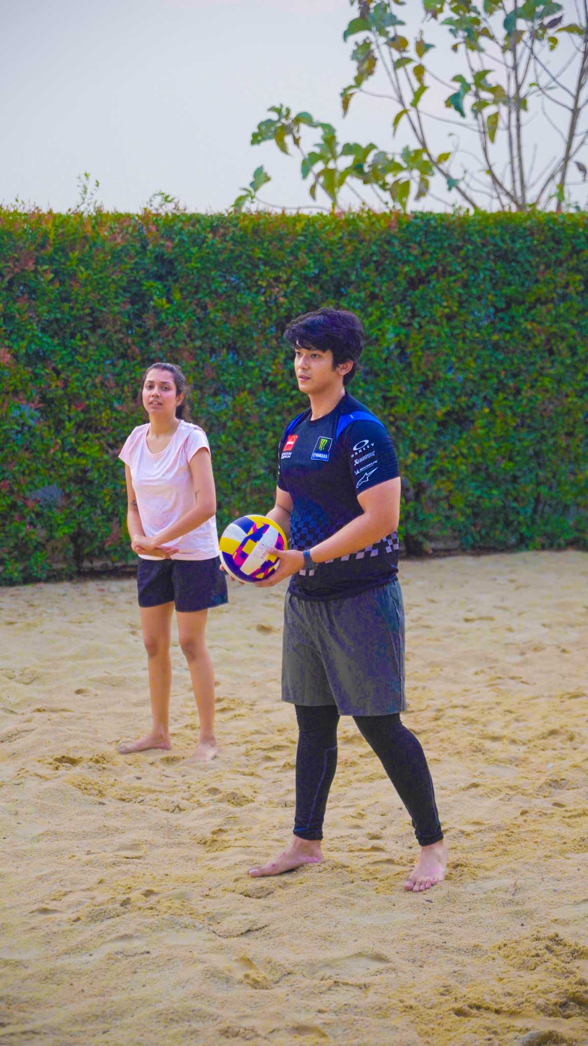Two young players on sandy court engaging in Bengaluru’s best beach volleyball experience, one holding a volleyball ready to serve.
