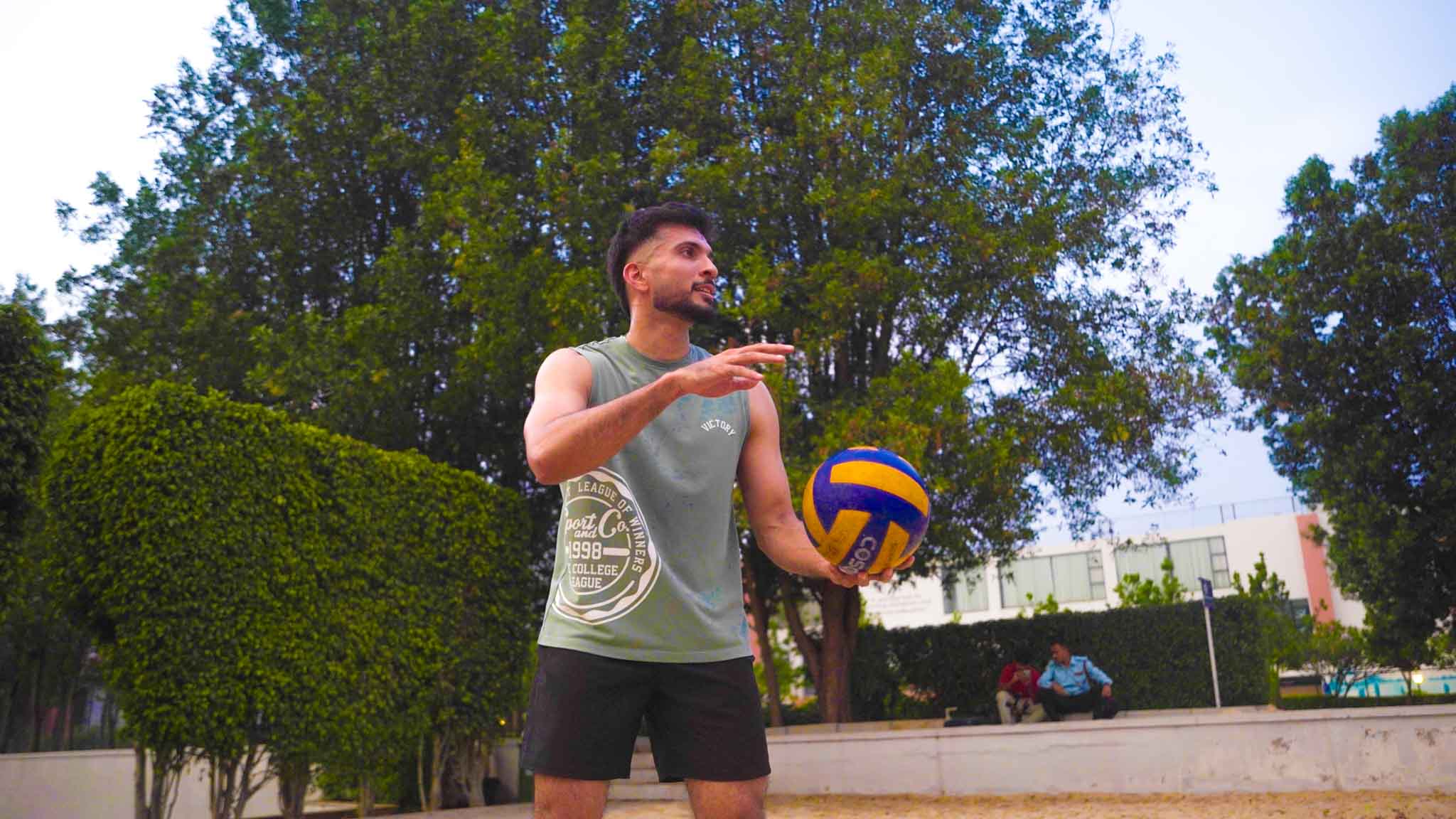 Man holding a volleyball getting ready to serve during a beach volleyball experience.