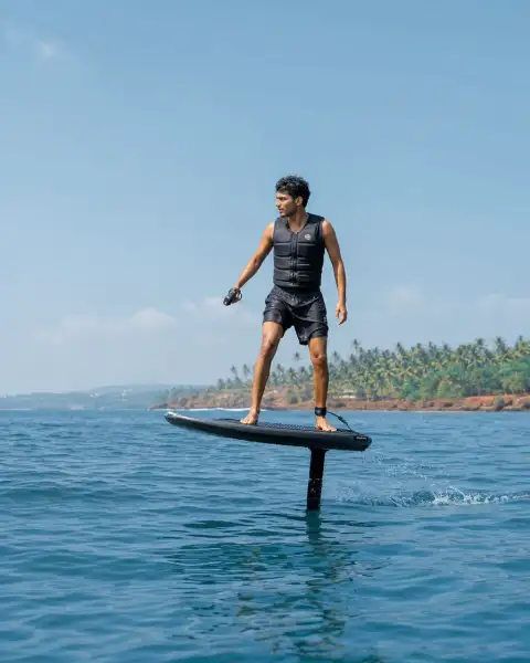 Portrait thumbnail: a single rider on an eFoil board at lift-off on open water, focused.