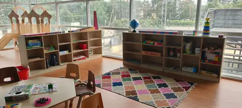 Lego tables, magnetic walls, art canvas, reading nook, and soft play modules.